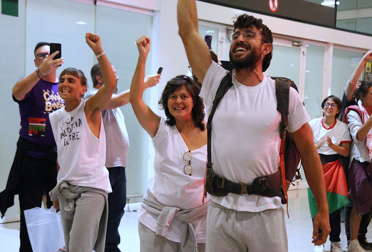 L'activista Ariadna Masmitjà, la diputada de la CUP Pilar Castillejo i Adrià Plazas, membre de la direcció de la CUP, celebrant la seva arribada a l'aeroport del Prat.