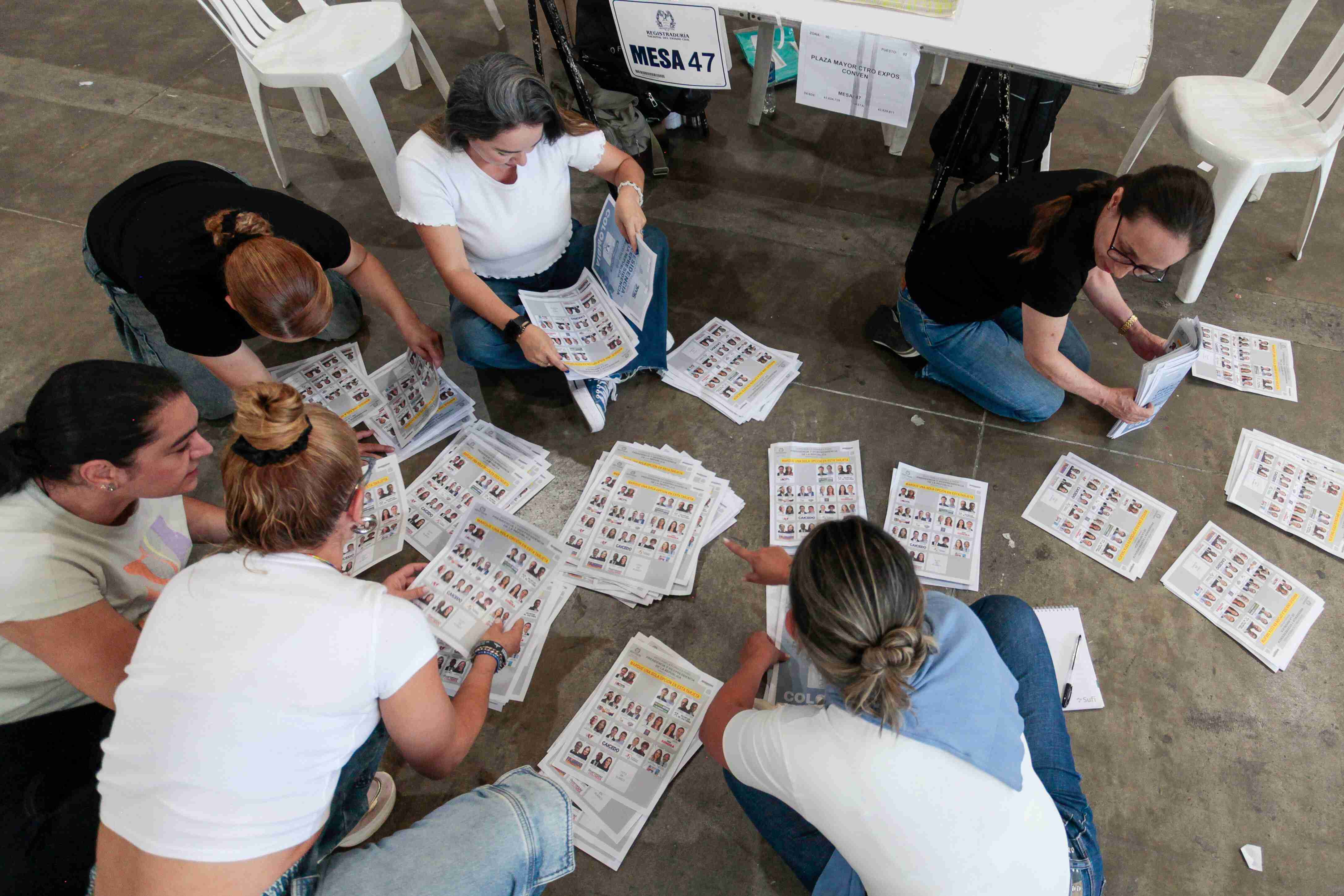 Diverses persones portant a terme el recompte de la primera volta de les eleccions presidencials, al centre de Medellín