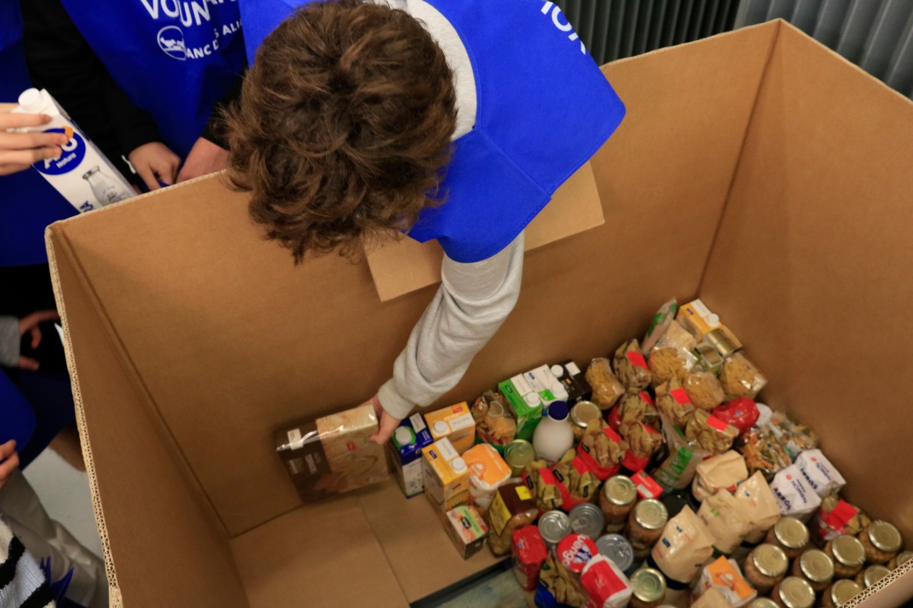 Un voluntari col·loca els aliments recollits. Un voluntari col·loca els aliments recollits.