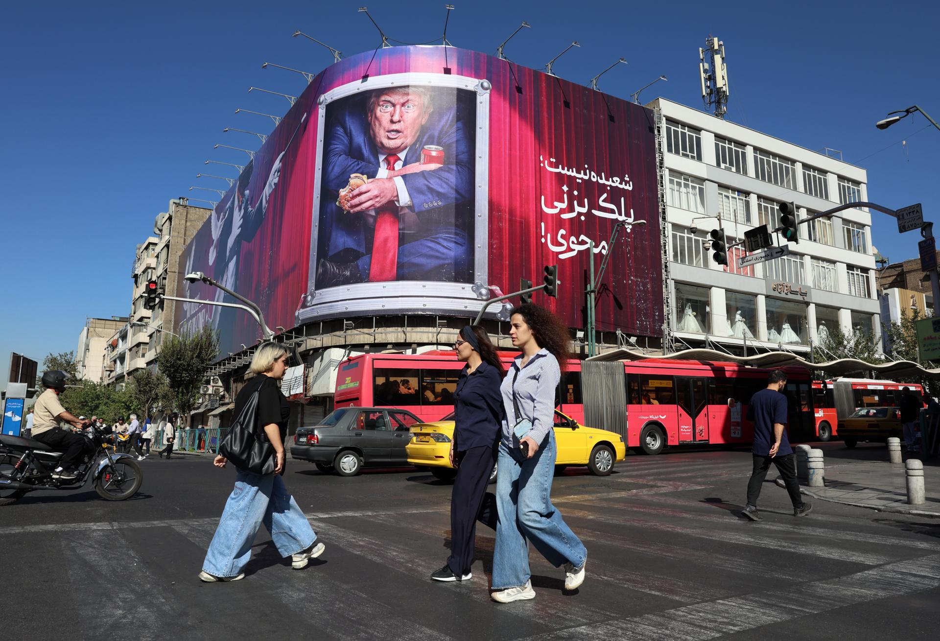 Iranians passen pel costat d'una tanca publicitària contra Trump en un carrer de Teheran Iranians passen pel costat d'una tanca publicitària contra Trump en un carrer de Teheran