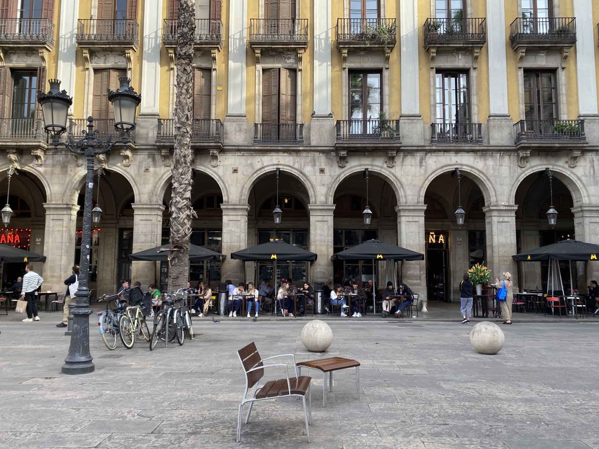 Banc individual i terrasses de bar a la plaça Reial de Barcelona Banc individual i terrasses de bar a la plaça Reial de Barcelona
